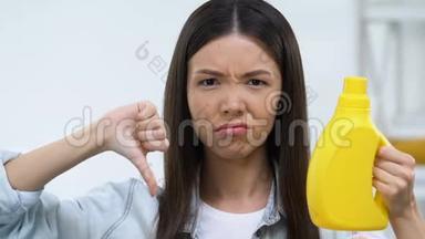 不满意的女人拿着洗洁精，竖起大拇指，不喜欢